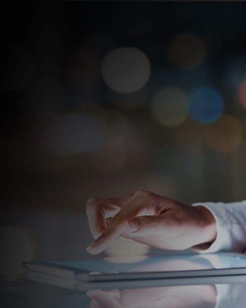 An image of a hand tapping on a tablet screen.