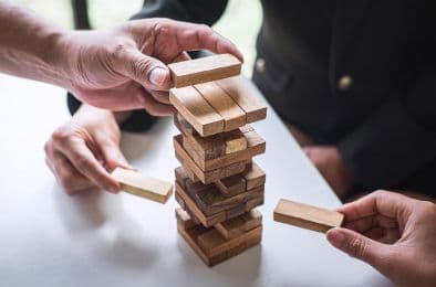 An image showing three people playing Jenga.