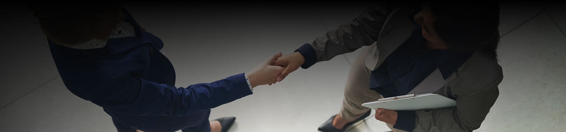 An image showing two people shaking hand with each other.