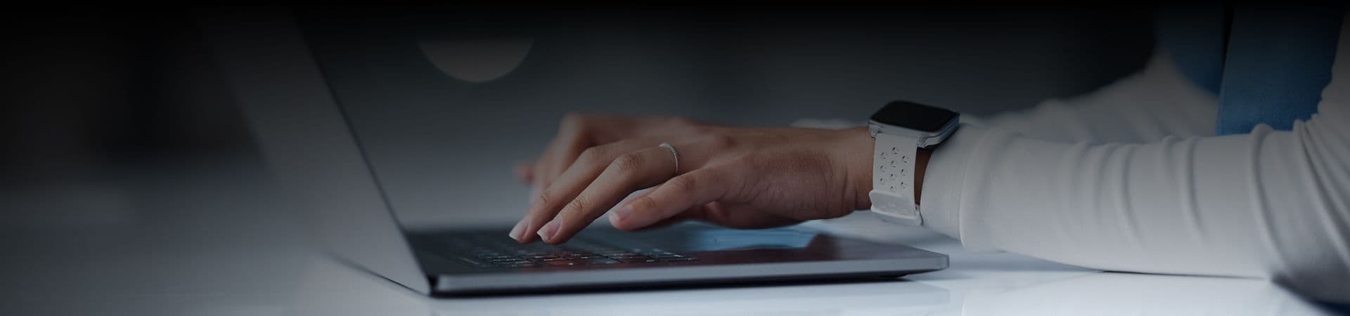 An image of a person's hand typing something on her laptop.