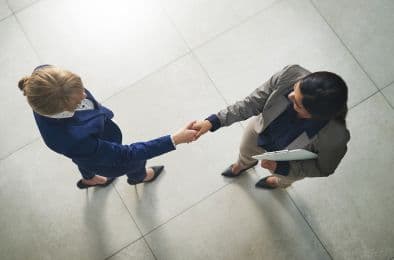 An image showing two people shaking hand with each other.